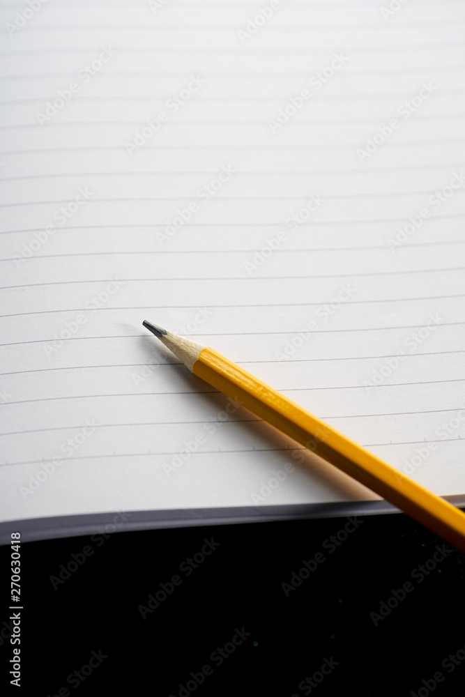 image of a notebooks and pencil on black background, close-up, selective focus image of a notebooks and pencil on black background, close-up, selective focus