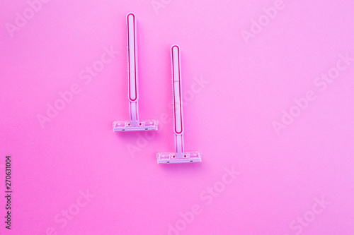 Two women's razors pink color on an isolated pink background.