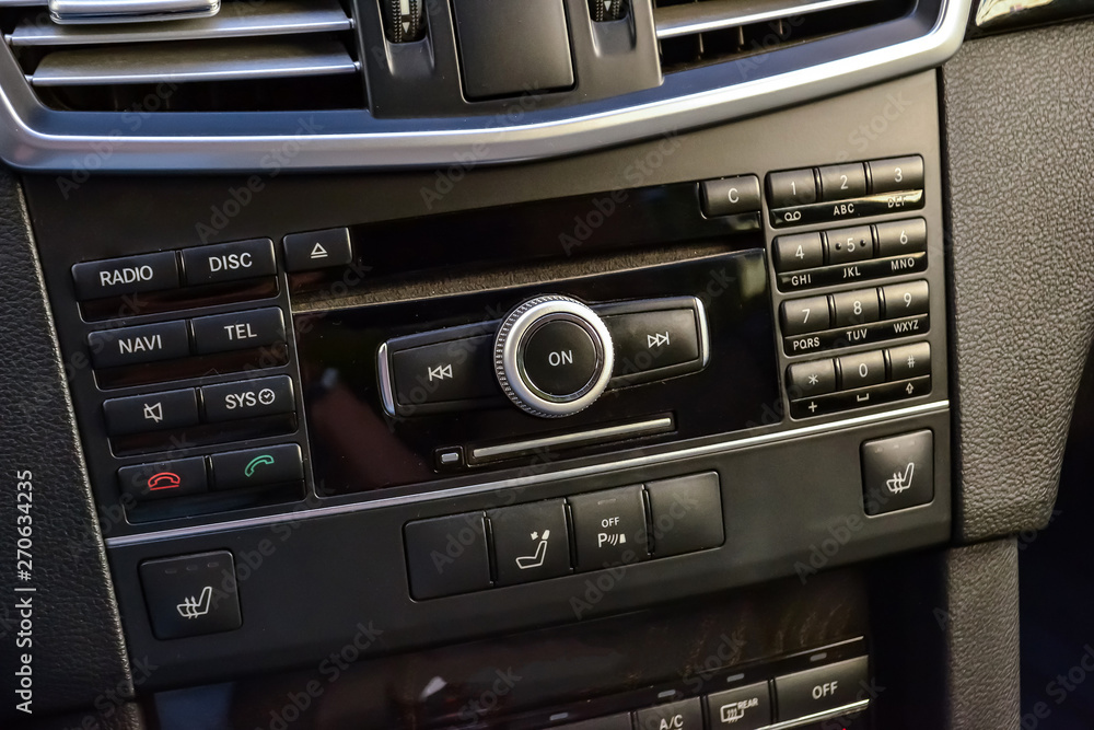 Fototapeta premium Control buttons for multimedia system, phone connected via bluetooth for talking on the speakerphone in the car on the black panel, heated seats and parking sensors.