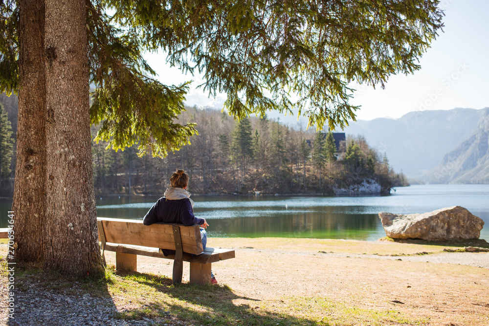 Woman sitting on a bench in a beautiful nature park. Woman sitting on a bench in a beautiful nature park.