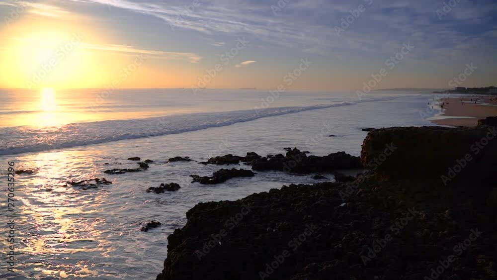 Panning from atlantic ocean waves to rocky beach landscape with large broken boulders and smaller coral like rocks shaped by water erosion at sunset, Panning from atlantic ocean waves to rocky beach landscape with large broken boulders and smaller coral like rocks shaped by water erosion at sunset,