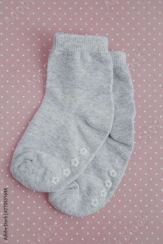 cute gray baby socks on a pink background © Evgeniya Primavera