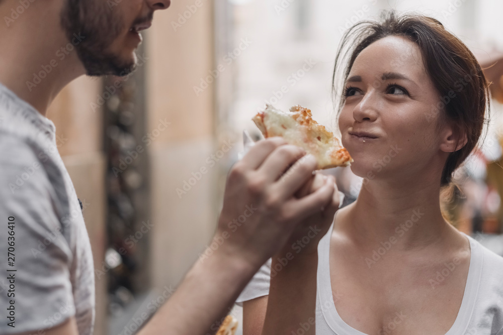 Young Couple Eating Pizza on the Street close to Fontana di Trev Young Couple Eating Pizza on the Street close to Fontana di Trev