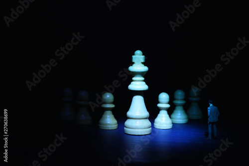 Concept picture of a businessman looking at chess figures and thinking about a plan of action