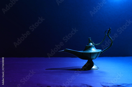 Image of magical mysterious aladdin lamp. Dark background and dramatic light photo