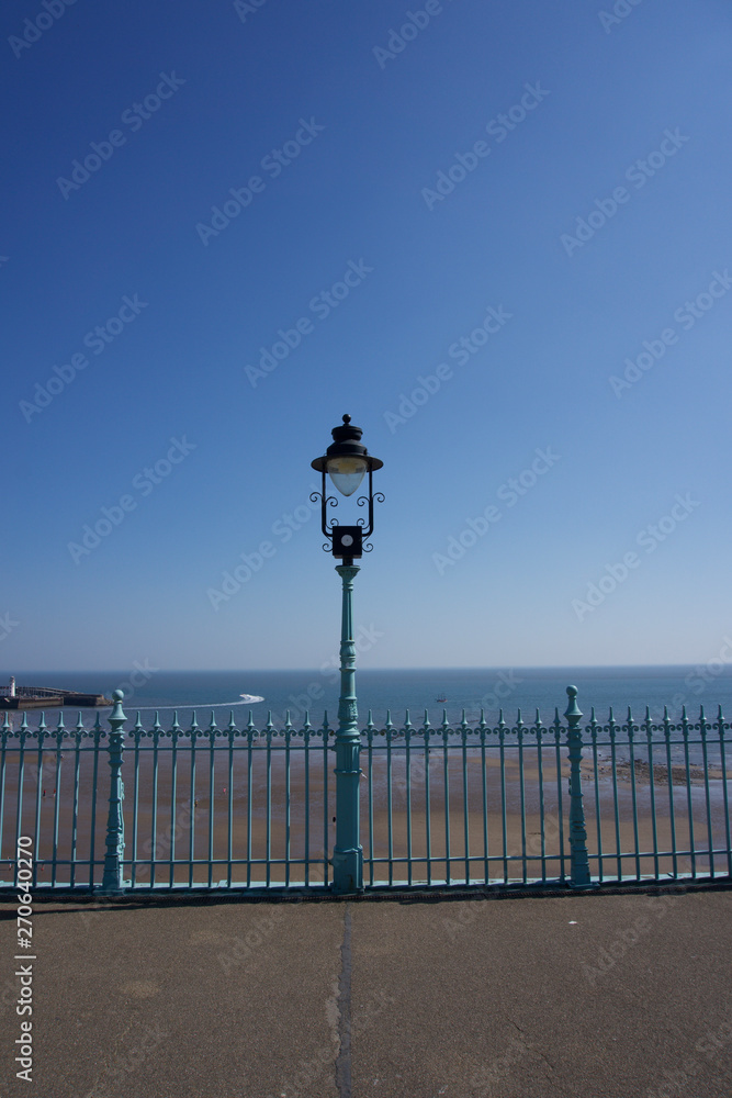 Obraz premium Lampost and railings in Scarborough, UK on a clear blue sky sunny day