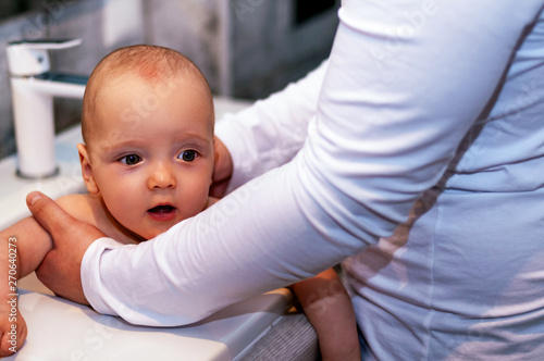 Dad washes the baby in the sink. Closeup baby. Paternity.