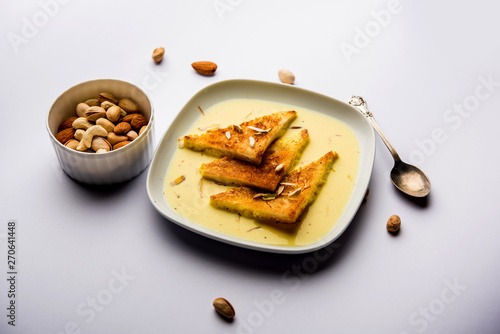 shahi tukra/tukda or Double ka meetha is a bread pudding Indian sweet of fried bread slices soaked in rabid or sweet saffron milk garnished with dry fruits, selective focus