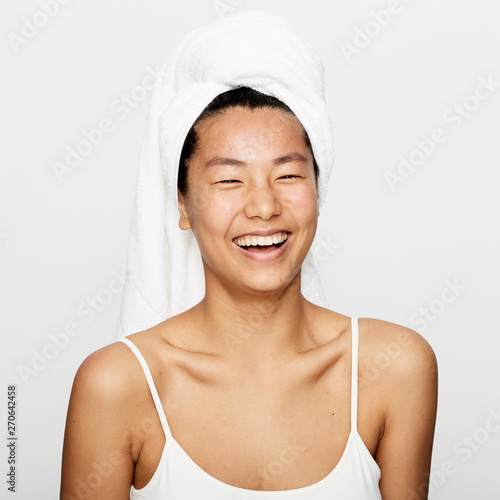 Young beautiful asian woman smiling after refreshing facial treatment.