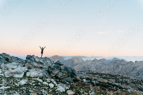 Hiker on mountain summit at sunset