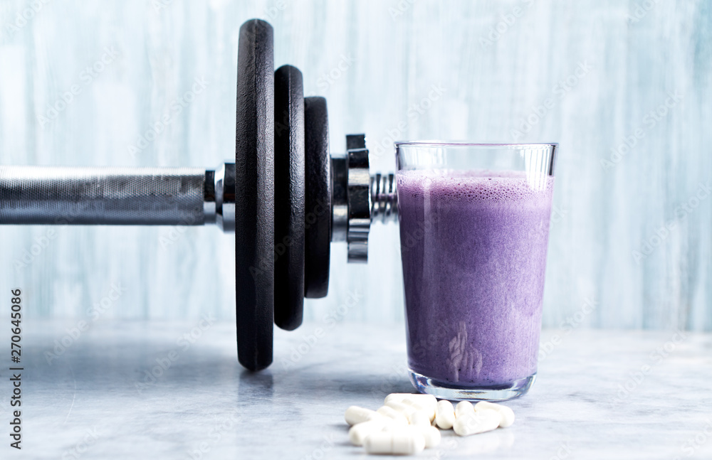Glass of Protein Shake with milk and blueberries, Betaalanine capsules