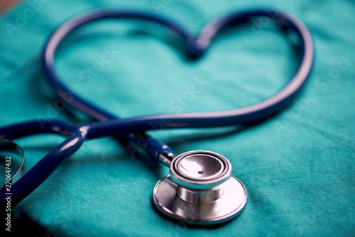 A stethoscope shaping a heart on a medical uniform, closeup photo