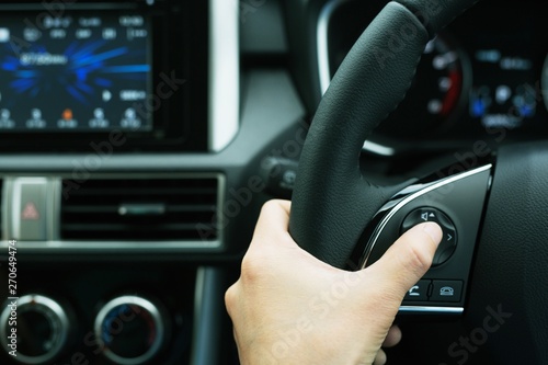 The concept of using hands to press the volume control switch in the car