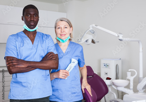 Dentist with assistant in the workplace in clinic