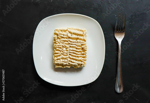 instant vermicelli with a fork on a black background. Theme Savings on Food. photo