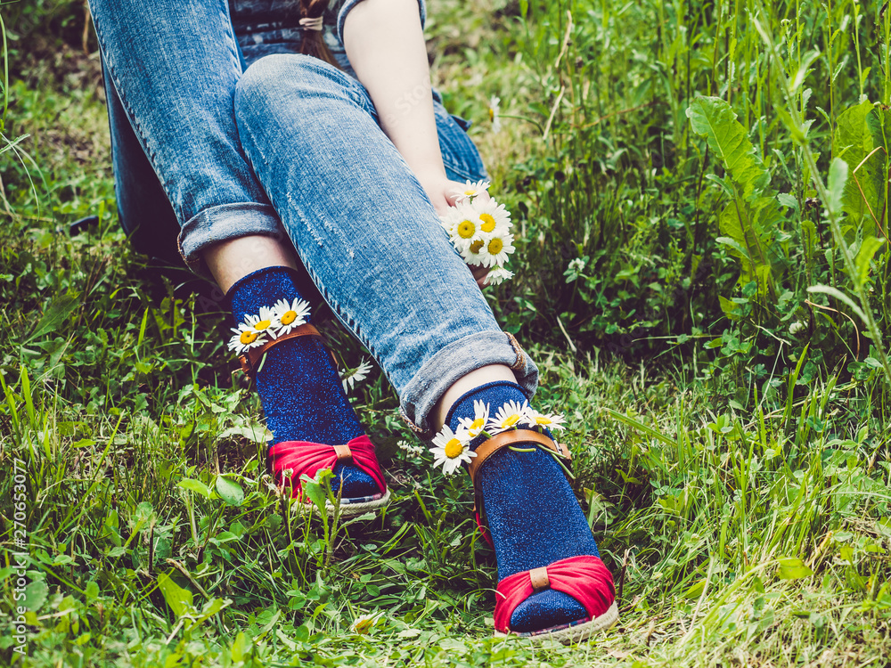 Women's legs, fashionable shoes, bright multi-colored socks on a background of green grass. Close-up. Concept of style, fashion and beauty Women's legs, fashionable shoes, bright multi-colored socks on a background of green grass. Close-up. Concept of style, fashion and beauty