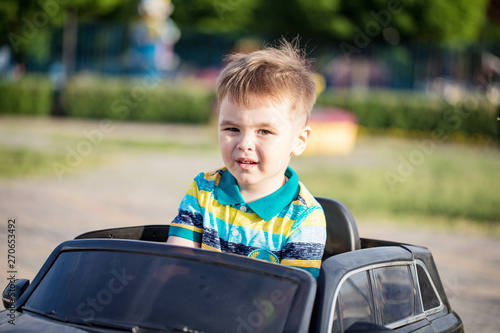 joy small boy is driving toy car on the playground   © Delete