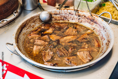 Warming braised pork belly in pan for Pork Belly Bun (Gua Bao) in street food market at Yuchi Township, Nantou County, Taiwan.