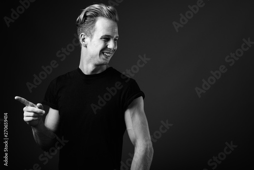 Studio shot of young handsome man against gray background in bla photo