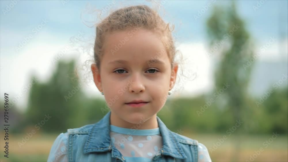 Close Up Portrait Cute Happy Caucasian Little Girl Smiling Looking the Camera, Enjoying Warm Summer Vacation Sunny day. Close Up Portrait Cute Happy Caucasian Little Girl Smiling Looking the Camera, Enjoying Warm Summer Vacation Sunny day.