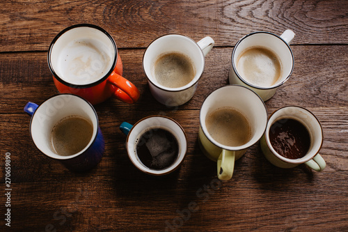 various mugs of coffee, wooden table, top view