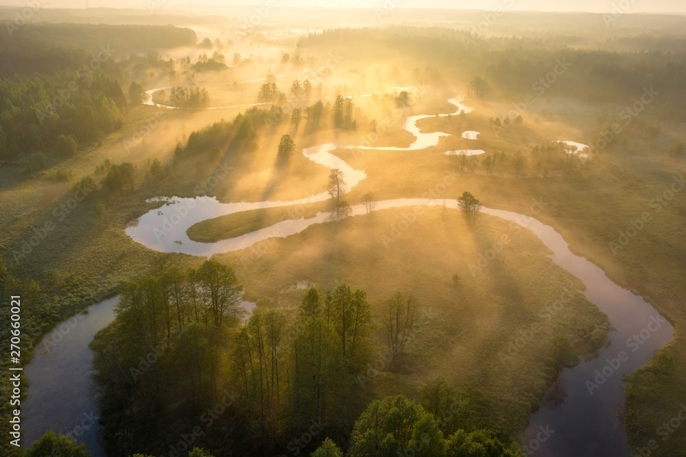 Summer nature landscape aerial view. Foggy morning river in sunlight. Sunny riverside from above. Amazing nature scene at misty sunrise