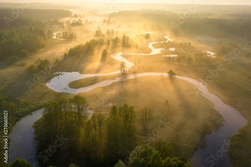 Obraz na płótnie Summer nature landscape aerial view. Foggy morning river in sunlight. Sunny riverside from above. Amazing nature scene at misty sunrise w salonie
