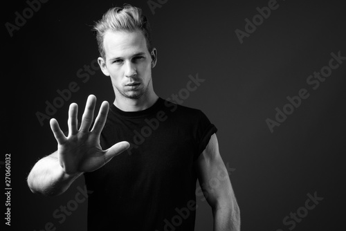 Studio shot of young handsome man against gray background in bla photo