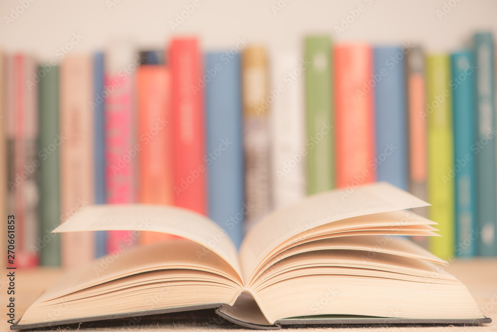 Fototapeta premium Open books close-up in library, toned pastel color background