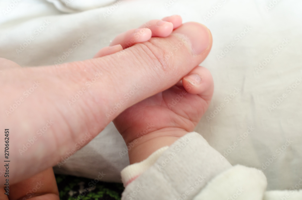Hand of newborn baby holding male adults finger. Concept of help and family. Father holding hand. Hand of newborn baby holding male adults finger. Concept of help and family. Father holding hand.