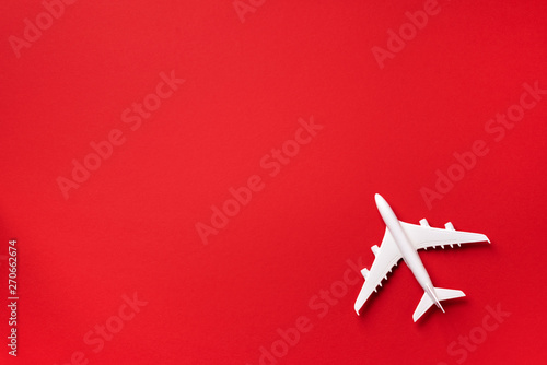 White plane, airplane on red color background with copy space. Top view, flat lay. Minimal style design. Travel, vacation concept