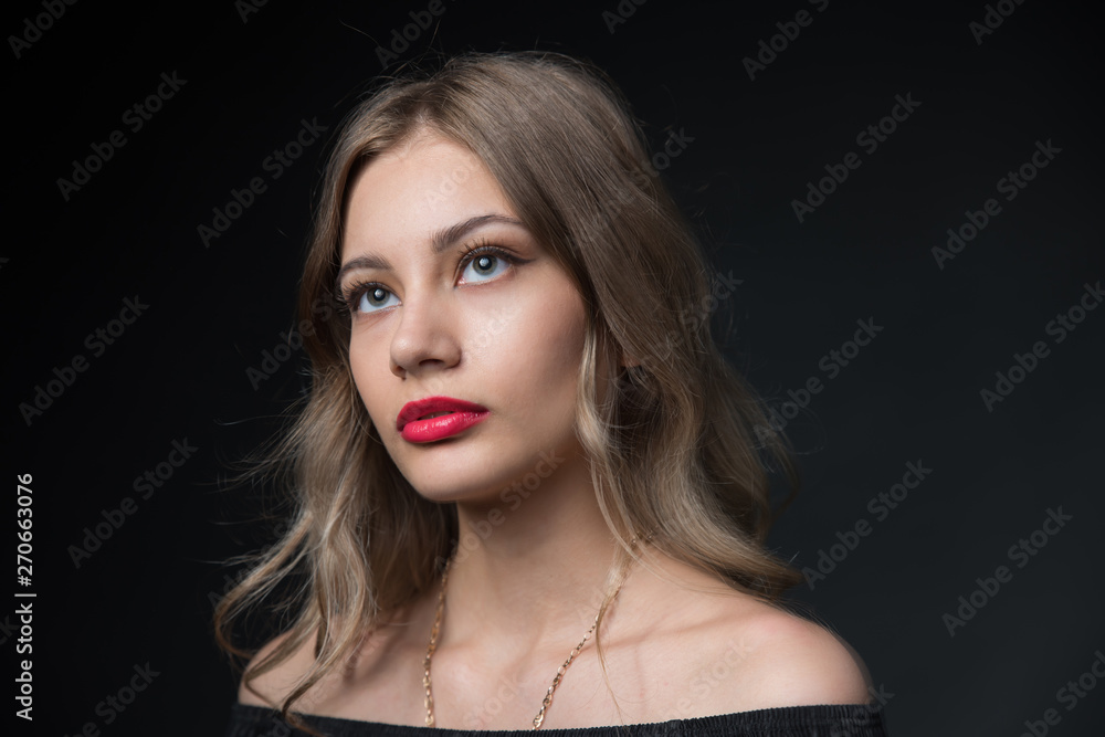 Beautiful ,young blonde with bright red lips and expressive eyes in a black jumpsuit. Beauty portrait of a girl. Emotional and bright appearance. Fashion portrait of a woman. Beautiful ,young blonde with bright red lips and expressive eyes in a black jumpsuit. Beauty portrait of a girl. Emotional and bright appearance. Fashion portrait of a woman.