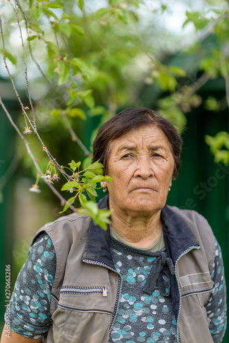 Portrait of an elderly woman in the village in the garden closeup.
