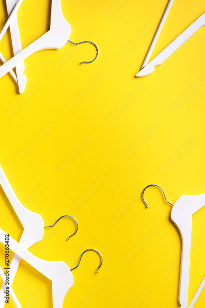 White clothes hangers on yellow background with copy space. Flat lay. Top  view. Minimalism style. Creative layout. Fashion, store sale, shopping  concept. Banner for feminine blog Stock Photo | Adobe Stock