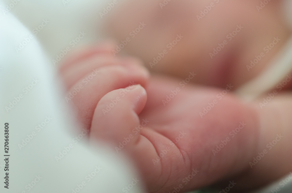 Hands of sleeping newborn baby. Face in shallow depth of field. Hands of sleeping newborn baby. Face in shallow depth of field.
