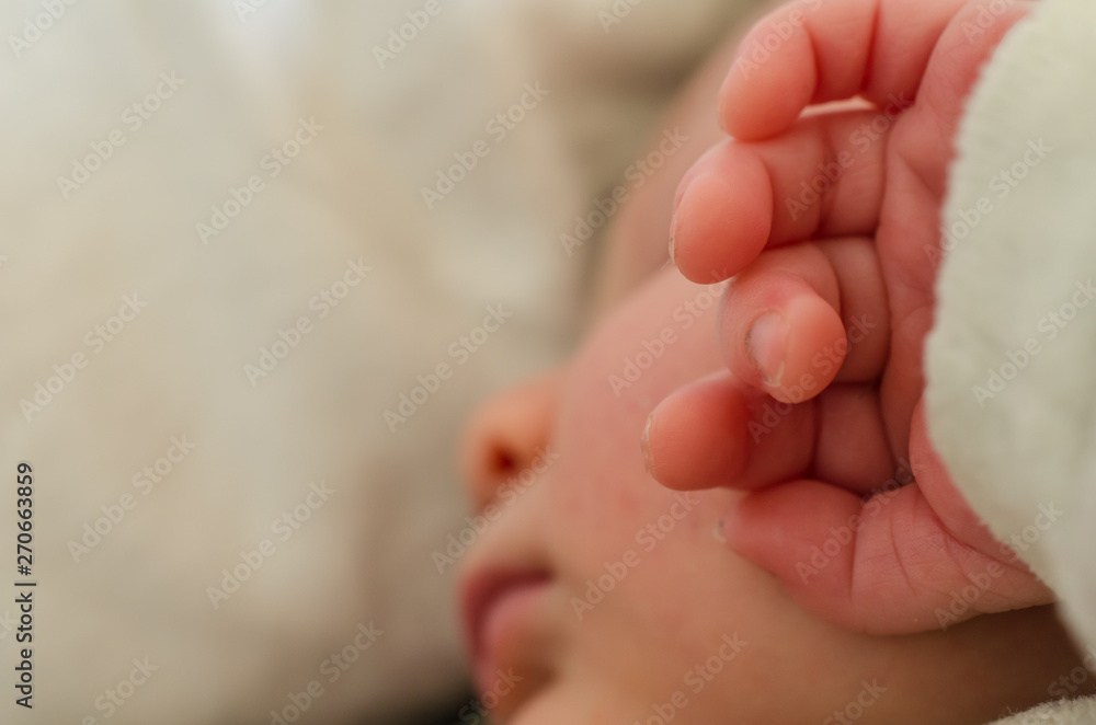 Hands of sleeping newborn baby. Face in shallow depth of field. Hands of sleeping newborn baby. Face in shallow depth of field.