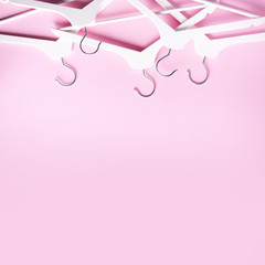 White clothes hangers on pink background with copy space. Flat lay. Top view. Minimalism style. Creative layout. Fashion, store sale, shopping concept. Banner for feminine blog