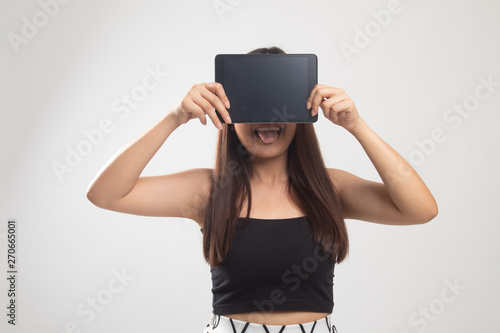 Young Asian woman with a computer tablet over her face.