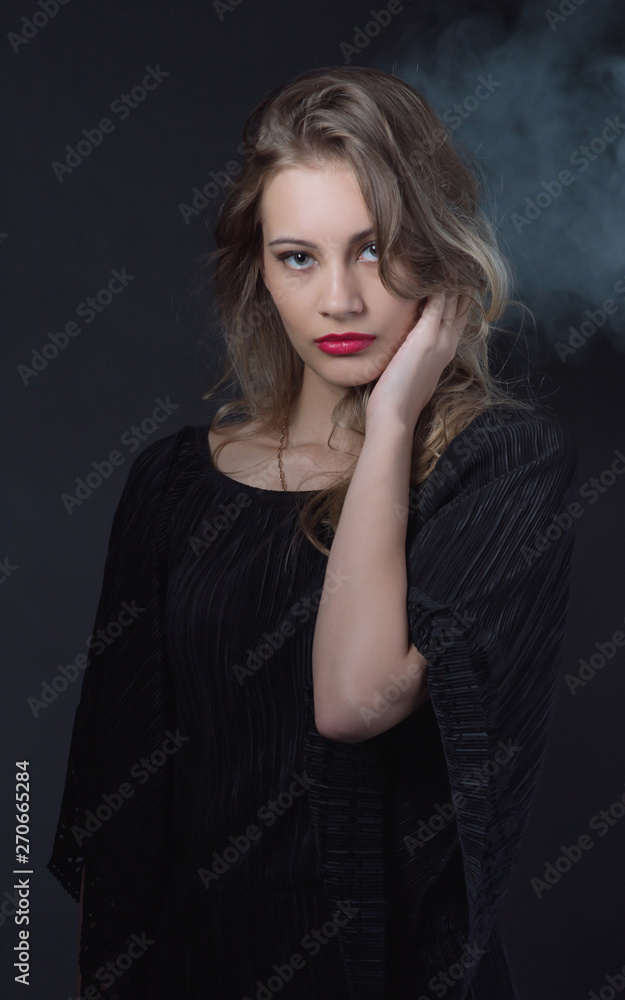 Beautiful ,young blonde with bright red lips and expressive eyes in a black jumpsuit. Beauty portrait of a girl. Emotional and bright appearance. Fashion portrait of a woman. Beautiful ,young blonde with bright red lips and expressive eyes in a black jumpsuit. Beauty portrait of a girl. Emotional and bright appearance. Fashion portrait of a woman.