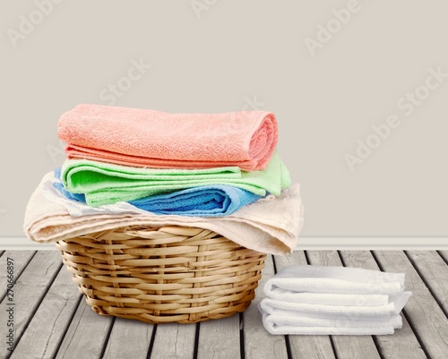 Laundry Basket with colorful towels on background