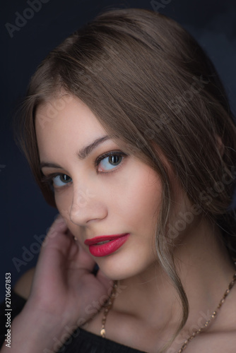 Beautiful  young blonde with bright red lips and expressive eyes in a black jumpsuit. Beauty portrait of a girl. Emotional and bright appearance. Fashion portrait of a woman.