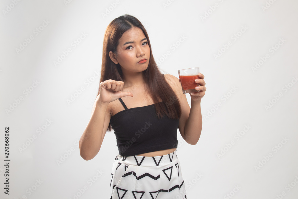 Asian woman thumbs down hate tomato juice. Asian woman thumbs down hate tomato juice.