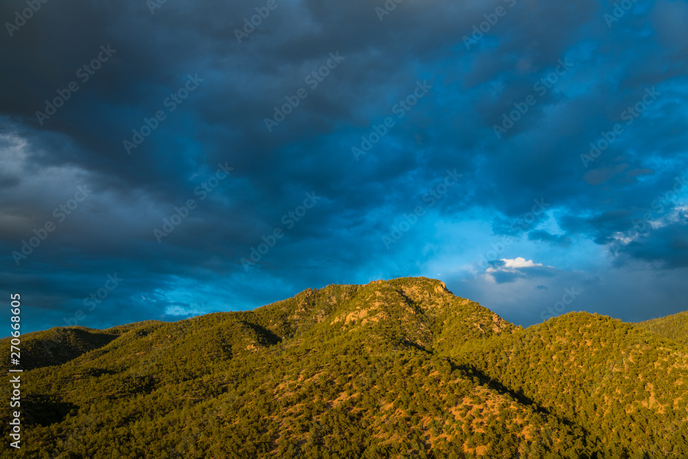 Obraz premium Piękne wieczorne niebo nad szczytem górskim otoczonym lasem jałowcowo-sosnowym - góry Sangre de Cristo w pobliżu Santa Fe w Nowym Meksyku