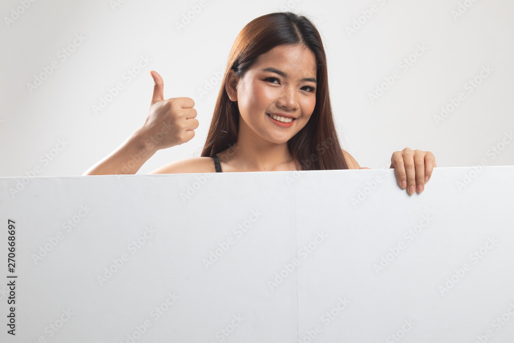 Fototapeta premium Young Asian woman show thumbs up with blank sign.