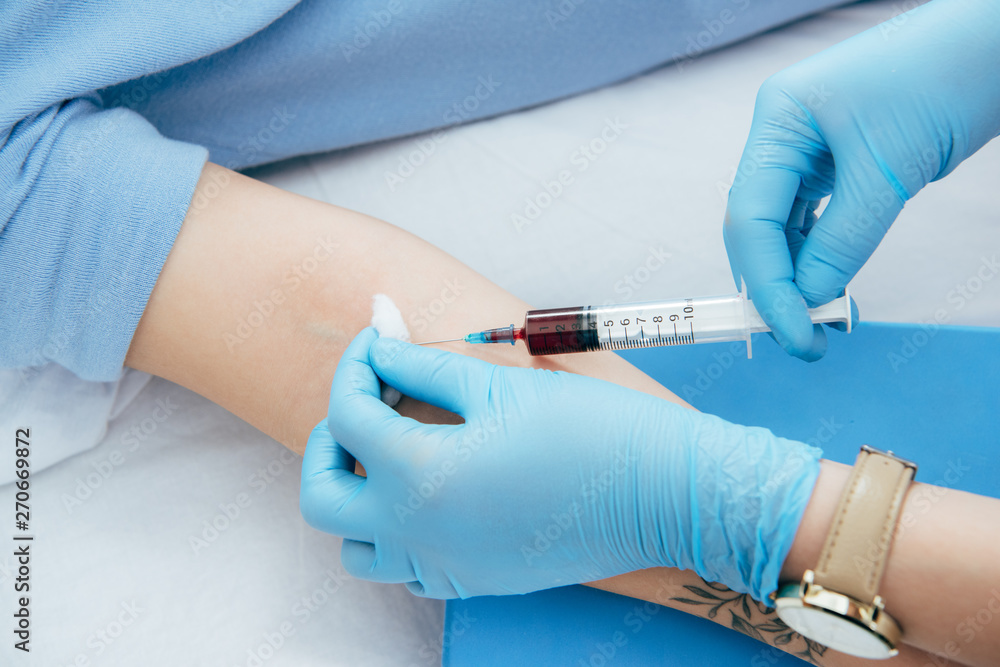 cropped view of donor and doctor with syringe obtaining blood sample cropped view of donor and doctor with syringe obtaining blood sample