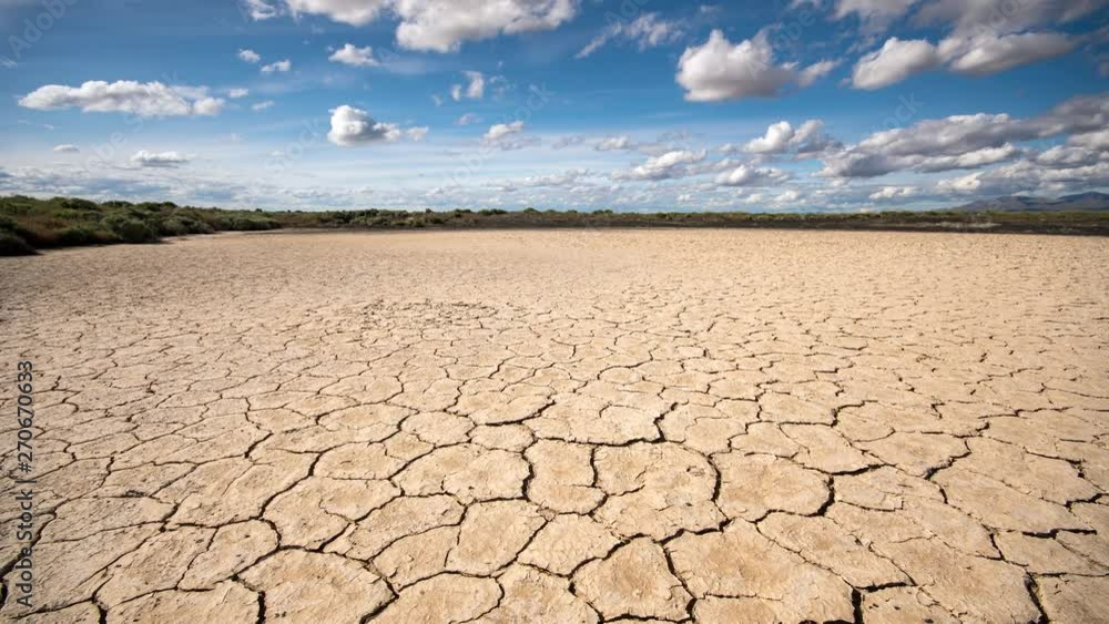 Panning over dry cracked sandy desert in Utah as clouds move through the sky in time lapse. Panning over dry cracked sandy desert in Utah as clouds move through the sky in time lapse.