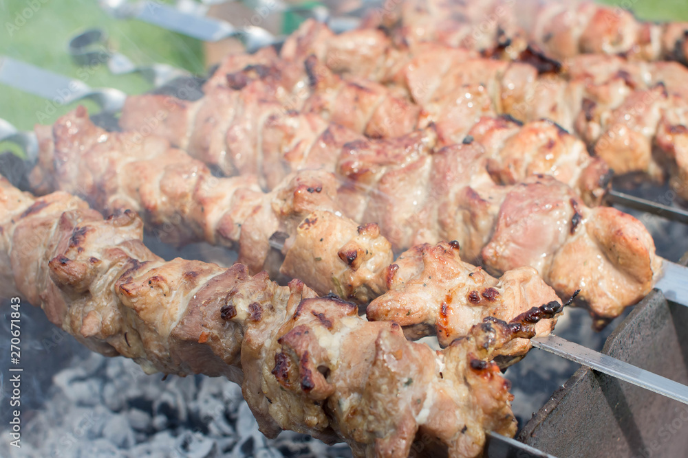 Shashlik pork on skewers close up. Meat roasted on an open fire on the grill. Selective focus.