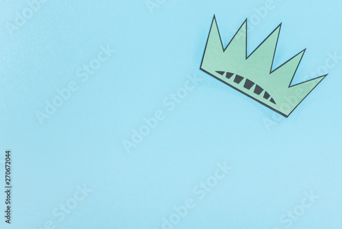 top view of paper cut crown on blue background with copy space, Independence Day concept