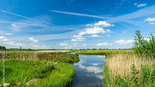 Obraz na plátně Beautiful polder landscape with the reflections of the sky in a wide ditch, near