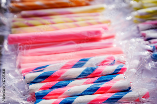 Close-up of colorful sugar sticks, sweet temptation in bright, fresh colors, sugary aromas, on a street market.